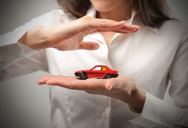 woman holding the model of a car