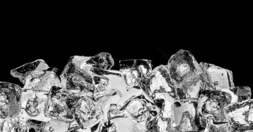 pieces of crushed ice cubes on black background.