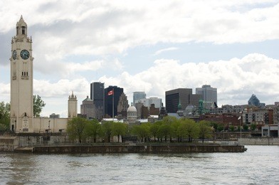 montreal clock tower (the sailor's  memorial clock) on a cloudy spring afternoon in old port, old montreal, quebec, canada. copy space above the city.