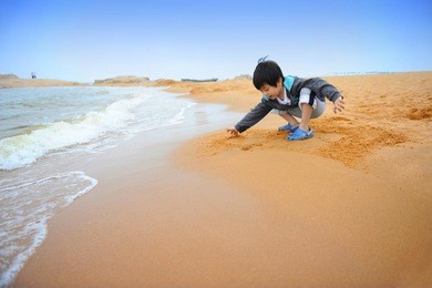 chinese boy playing on the beach