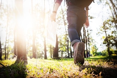 young man traveler with backpack relaxing outdoor with rocky mountains on background summer vacations and lifestyle hiking concept