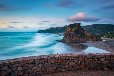 lion rock, piha beach at sunset | auckland, new zealand