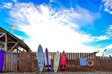 surf boards standing along the fence