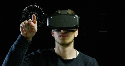portrait of young man with 3d virtual reality glasses enjoys his trip in an adventurous world on a dark background. concept of connection technology with science, augmented future, global web