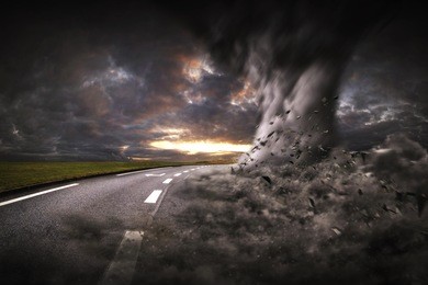 view of a large tornados destroying the landscape and a road