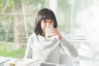 beautiful asian girl drinking  glass of water in a restaurant