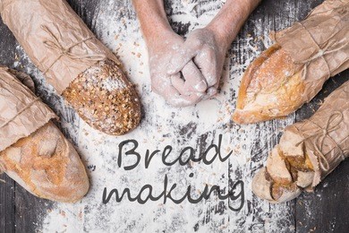 bread making. lots of different bread sorts, wrapped in craft paper. baking and cooking concept background. hardworking hands of baker on wooden table, sprinkled with flour.
