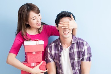 young couple with gift isolated on blue background