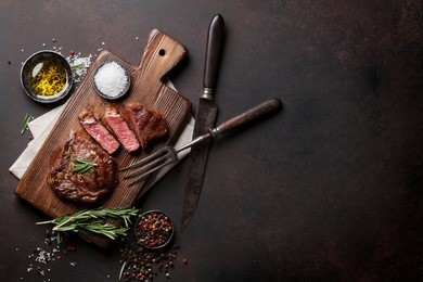 grilled ribeye beef steak, herbs and spices. top view with copy space for your text