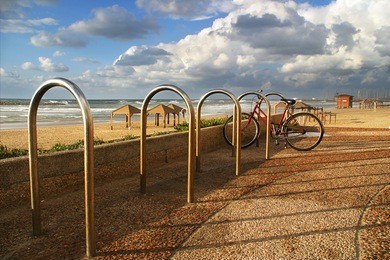 bicycle on promenade along the shore of mediterranean sea under the cloudy sky in tel aviv, israel.