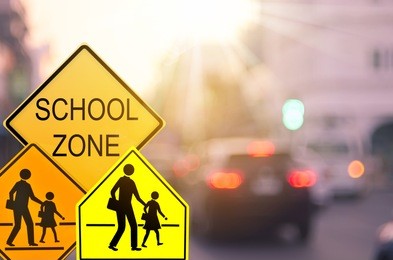 set of school zone warning sign on blur traffic road with colorful bokeh light abstract background. copy space of transportation and travel concept. vintage tone filter effect color style.  