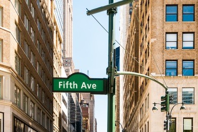new york city fifth aveneu signpost with old building