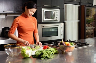 woman cutting vegetables in kitchen, portrait