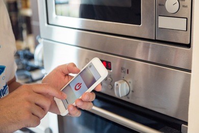 smart home: man controlling kitchen with app on his phone