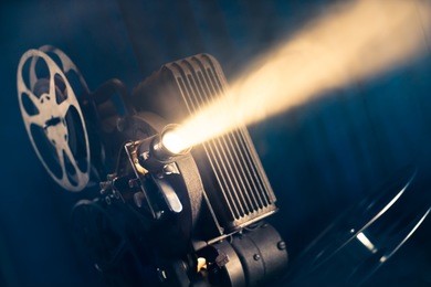 film projector on a wooden background with dramatic lighting and selective focus