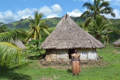 indigenous fijian man dressed in traditional fijian costume, stand outside his bure hut at navala village in ba highlands on viti levu island, fiji. real people, copy space