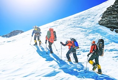 group of climbers reaches the top of mountain peak. climbing and mountaineering sport. teamwork concept.
