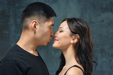 portrait of smiling korean couple on a gray