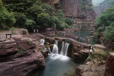 natural red stone bridge across waterfall in yuntaishan china