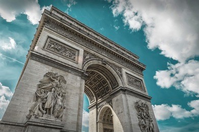 arc de triomphe in paris under sky with clouds. one of symbols of france and one of the most popular tourist places in the world.
