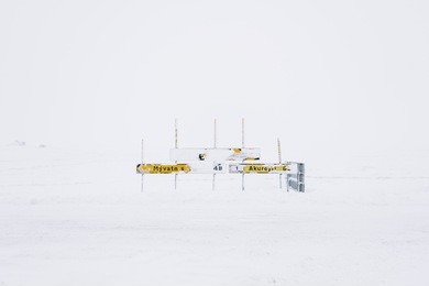 icelandic cities road sign covered in snow in the middle of nowhere