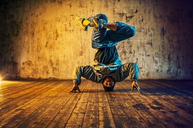 young man break dancing on wall background. vibrant blue and red colors effect.