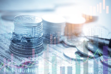 double exposure of city and coin stack on banking account in the background with chart and graph
