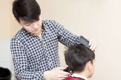 hairdresser cuts client's hair. rear view of man in the barber shop.