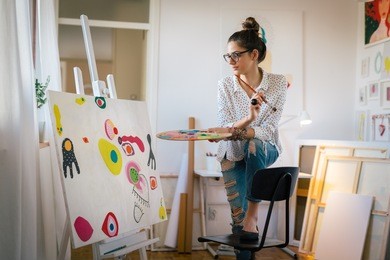 bringing her creativity to life. woman painting in her art studio
