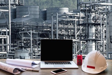 engineering industry concept in office with oil and gas industry,refinery at sunset ,pipelines and petrochemical plant background 