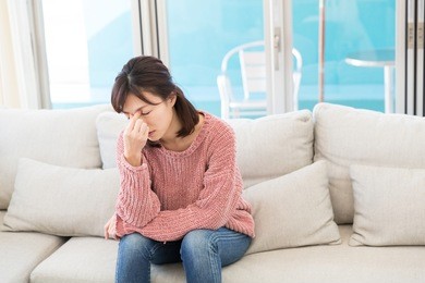 young attractive asian woman who has a pain in a head