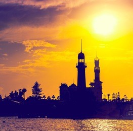 silhouettes of lighthouse and royal palace in montaza park, cityscape of alexandria. montazah national park at sunset - architectural landmarks from travel to egypt on mediterranean sea.