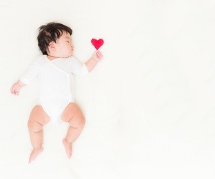 adorable asian baby girl with heart and copy space for valentine concept background.