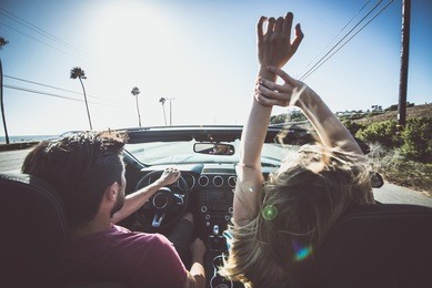 couple driving on a convertible car