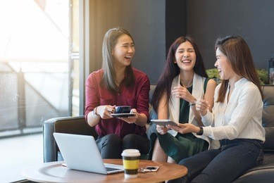 3 teenagers friends meet in coffee shop, using technology device have fun