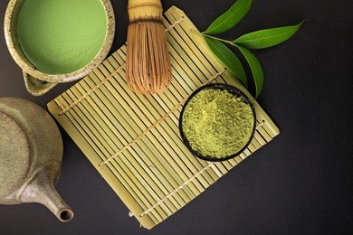 matcha fine powdered green tea on back background.