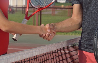 young players shaking hands on tennis court, only hands can be seen. healthy fitness concept with active lifestyle.