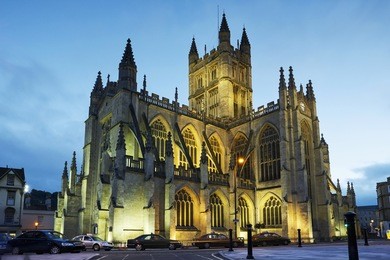 facade of the gothic 'bath abbey' illuminated at dusk in royal bath spa