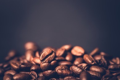 brown roasted coffee beans, seed on dark background. espresso dark, aroma, black caffeine drink. closeup isolated energy mocha, cappuccino ingredient.