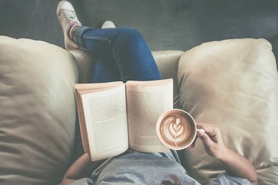 soft photo of young girl reading a book and drinking coffee, top view