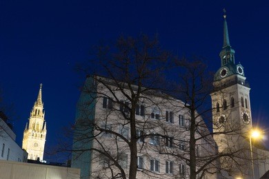 night shot of st. peter's church (peterskirche) on the right and rathausgalerie in marienplatz in munich, germany
