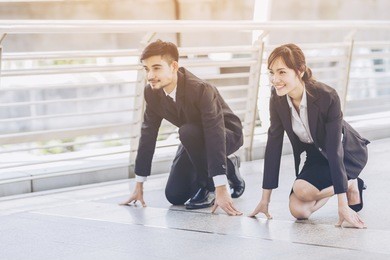 businessman with businesswoman starting position to his career with on city background,love couple starting position to the finish line,portrait of asian couple on the starting position