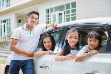 beautiful family portrait smiling outside their new house, just arrive new home by car.