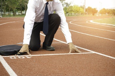 business man ready at start line and holding briefcase