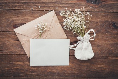 empty greeting card and flowers on wooden background. love letter. flay lay composition. top view