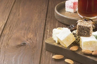 black tea, oriental sweets, dates and nuts on a dark wooden background. copy space. food background. toning.