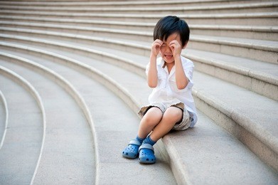 asian boy crying on stairs
