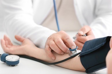 doctor measuring blood pressure of patient