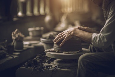 craftsman artist making craft, pottery, sculptor from fresh wet clay on pottery wheel, selected focus