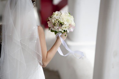 bride back with rose bouquet in hand on wind